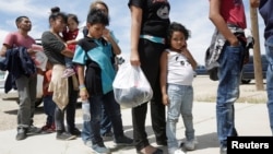 Central American migrants stand in line before entering a temporary shelter, after illegally crossing the border between Mexico and the U.S., in Deming, New Mexico, May 16, 2019.