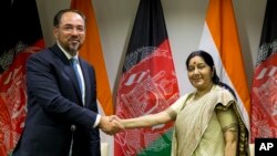 Menlu Afghanistan Salahuddin Rabbani (kiri) berjabat tangan dengan Menlu India Sushma Swaraj usai penandatanganan kesepakatan di New Delhi, India 11 September lalu (foto: dok). 