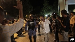 Supporters of Maldives' former President Mohamed Nasheed taunt a police officer during a protest in Male, Maldives, Sunday, Feb. 12, 2012.