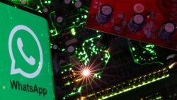 Sebuah ponsel menampilkan logo WhatsApp di atas motherboard dalam ilustrasi ini, 23 Februari 2023. (Foto: Reuters)