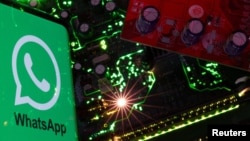 Sebuah ponsel menampilkan logo WhatsApp di atas motherboard dalam ilustrasi ini, 23 Februari 2023. (Foto: Reuters)