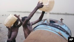 Des enfants remplissent un réservoir d'eau du fleuve Nil à Khartoum, au Soudan, 5 mai 2009. 