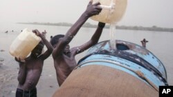 Des enfants soudanais remplissent un réservoir d'eau du fleuve Nil à Khartoum, au Soudan, 5 mai 2009. 