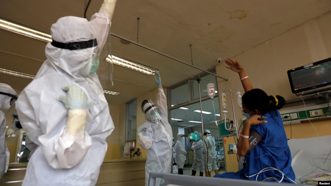 Nakes di RS Persahabatan mengajak seorang pasien di Unit Perawatan Intensif (ICU) khusus pasien COVID-19, berolahraga, 13 Mei 2020. (Foto: Reuters/ilustrasi)