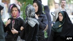 FILE - An Iranian policewoman (R) warns women about their clothing and hair during a crackdown to enforce Islamic dress code in Tehran, April 23, 2007.