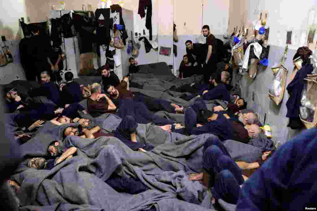 Foreign prisoners, suspected of being part of the Islamic State terror group, lie in a prison cell in Hasaka, Syria.