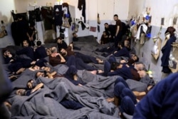 FILE - Foreign prisoners, suspected of being part of the Islamic State terror group, lie in a prison cell in Hasaka, Syria, Jan. 7, 2020.