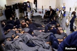 FILE - Foreign prisoners, suspected of being part of the Islamic State terror group, lie in a prison cell in Hasaka, Syria, Jan. 7, 2020.
