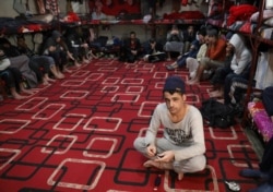 FILE - Prisoners from Iraq and Syria, suspected of being part of the Islamic State, sit inside a prison cell in Hasaka, Syria, Jan. 11, 2020.