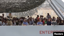 Migrants arrive on the British vessel HMS Enterprise before disembarking in the Sicilian harbor of Catania, Italy, Oct. 6, 2015. The Italian coastguard said on Tuesday some 1830 migrants were rescued from the Mediterranean sea in a twenty-four hour period