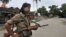 FILE - An Indian armed security man stands guard in Kokrajhar, India, July 24, 2012. Authorities say 15 people were wounded in the attack Friday in Kokrajhar, 220 kilometers west of the state commercial capital, Guwahati.