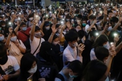 Pro-democracy demonstrators in June 2020 shine flashlights on their mobile phones to mark the one-year anniversary of a mass rally against a controversial extradition bill.