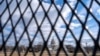 A bird, framed by security fencing, flies in front of the U.S. Capitol, Jan. 2, 2025, in Washington. The fencing has been put up around the Capitol complex in preparation for a series of upcoming events in the nation's capital.