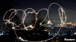 A girl with sparkle writes 2020 during the New Year&#39;s celebrations in North Macedonia.