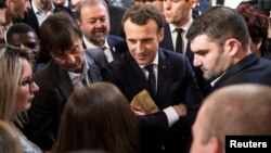 French President Emmanuel Macron, center, speaks with guests next to Minister of the Ecological and Social Transition Nicolas Hulot, left, and French President of the Young Farmers Association Jeremy Decerle, right, after he delivered a speech to the young French farmers invited at the Elysee Palace before the opening of the 2018 Paris International Agricultural Show in Paris, France, Feb. 22, 2018.