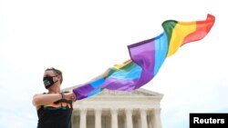 Joseph Fons holds a Pride Flag and stands in front of the U.S. Supreme Court building in Washington, D.C., after the court ruled that a federal law banning workplace discrimination also covers sexual orientation.