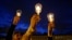 FILE - Demonstrators light candles during a candlelight vigil for slain activists in Bogota, Colombia, July 6, 2018.