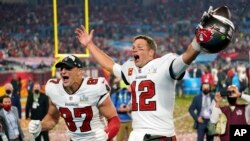 FILE - Tampa Bay Buccaneers quarterback Tom Brady (12) and tight end Rob Gronkowski, celebrate after the NFL Super Bowl 55 football game against the Kansas City Chiefs in Tampa, Florida, Feb. 7, 2021.