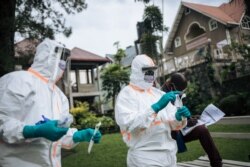 Staff members of the Congolese Ministry of Health perform a COVID-19 test at a private residence in Goma, northeastern Democratic Republic of Congo, March 31, 2020.