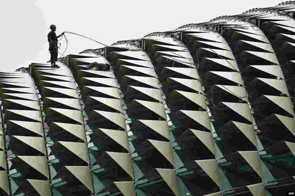 Workers do maintenance on the roof of the Esplanade theater in Singapore.