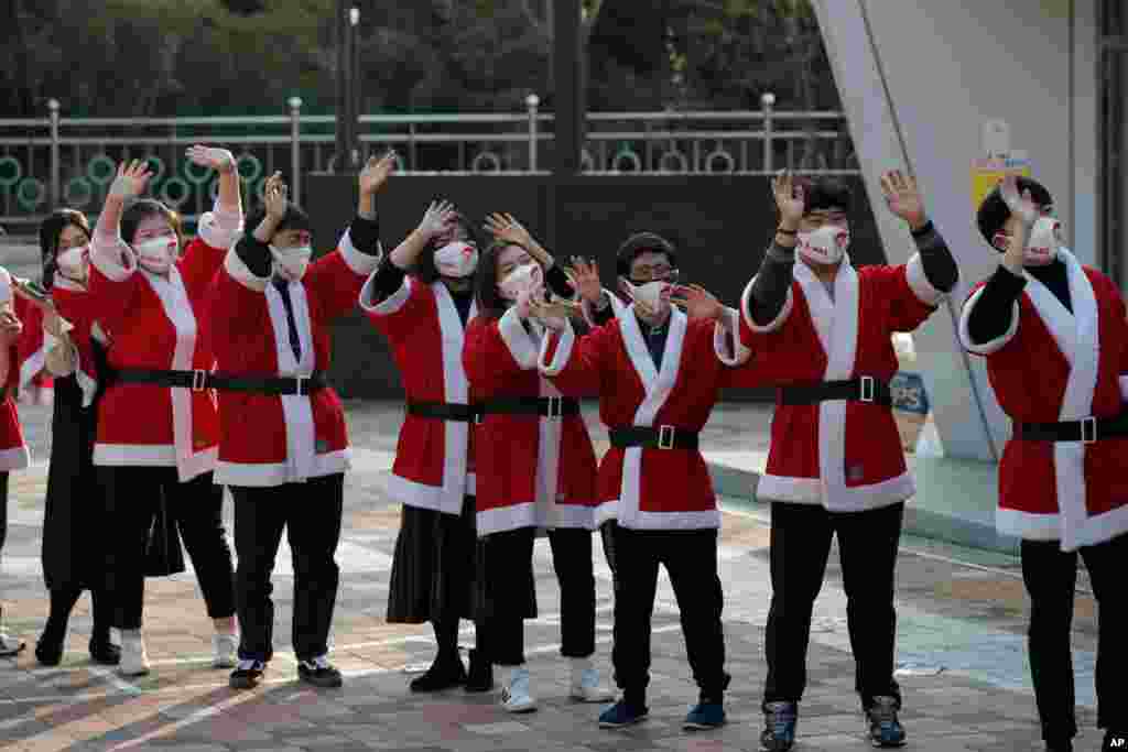 چند داوطلب کمک به مردم در آستانه کریسمس، در شهر سئول در لباس بابانوئل عکس یادگاری می‌گیرند. 