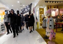 Protesters carry a flag reading "Liberate Hong Kong, the Revolution of Our Times" as they march through a shopping mall in Causeway Bay in Hong Kong, Dec. 26, 2019.