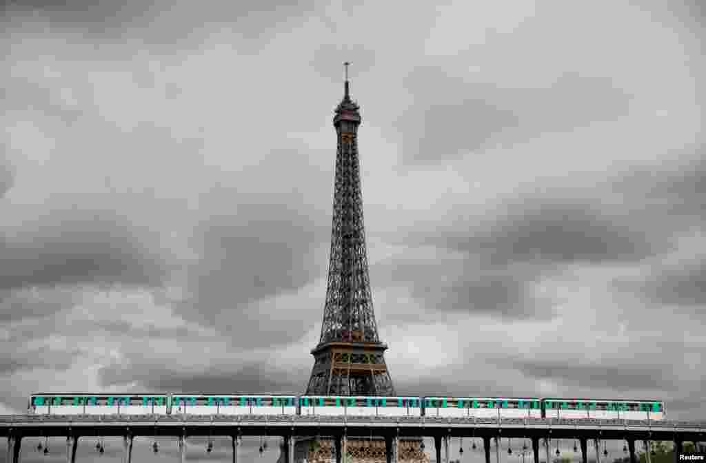 An elevated Metro passes over a bridge next to the Eiffel Tower in Paris on the eve of a strike by all unions of the Paris transport network (RATP) against pension reform plans, France.