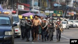 police march with a resident arrested during a crackdown on protesters 