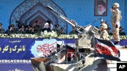 FILE - Iran's President Hassan Rouhani, center, reviews a military parade during the 37th anniversary of Iraq's 1980 invasion of Iran, in front of the shrine of the late revolutionary founder, Ayatollah Khomeini, just outside Tehran, Iran, Sept. 22, 2017.