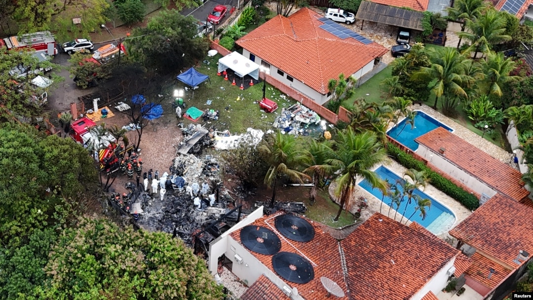 A drone view shows people working at the site of a plane crash in Vinhedo, Sao Paulo, Brazil, Aug. 10, 2024.