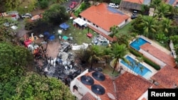 A drone view shows people working at the site of a plane crash in Vinhedo, Sao Paulo, Brazil, Aug. 10, 2024.