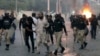 Police detain a supporter of the Tehreek-e-Labbaik Pakistan party during clashes with its members in Karachi, Pakistan, Oct. 13, 2024.