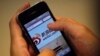 FILE - A man holds an iPhone as he visits the Sina Weibo microblogging site (China's version of Twitter) in Shanghai.