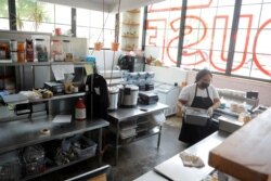 미국 볼티모어에서 신종 코로나바이러스 사태로 영업에 어려움을 겪는 식당들을 위해 만들어진 간이 푸드코트에서 종업원들이 음식을 만들고 있다.