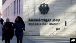 FILE - People walk past the German Foreign Ministry building in Berlin, Germany.