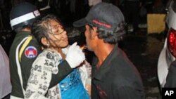 Injured people being carried by police and civilians after a deadly stampede in Phnom Penh, Cambodia, Nov. 22, 2010