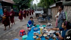 မန္တလေးမြို့တနေရာတွင် မနက်စာ စားနေသူများနှင့် ဆွမ်းခံကြွသံဃာတော်များ။ ဒီဇင်ဘာ ၁၊ ၂၀၁၂။