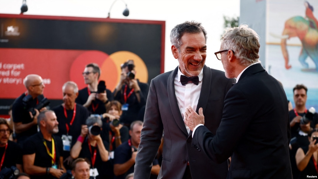 Sutradara Todd Phillips dan pemeran Joaquin Phoenix berpose di karpet merah setibanya di pemutaran film "Joker: Folie a Deux" di Festival Film Venesia ke-81 di Venesia, Italia, 4 September 2024. (Yara Nardi/REUTERS)