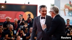 Sutradara Todd Phillips dan pemeran Joaquin Phoenix berpose di karpet merah setibanya di pemutaran film "Joker: Folie a Deux" di Festival Film Venesia ke-81 di Venesia, Italia, 4 September 2024. (Yara Nardi/REUTERS)