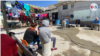 Inmigrantes aguardan sentados en el patio del refugio El Buen Samaritano, en Ciudad Juárez, México, su hogar durante la larga espera, en ocasiones, ya de años.