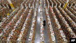 FILE - An Amazon.com employee stocks products along one of the many miles of aisles at an Amazon.com Fulfillment Center in Phoenix, Arizona, on "Cyber Monday" the busiest online shopping day of the holiday season, December 2013.