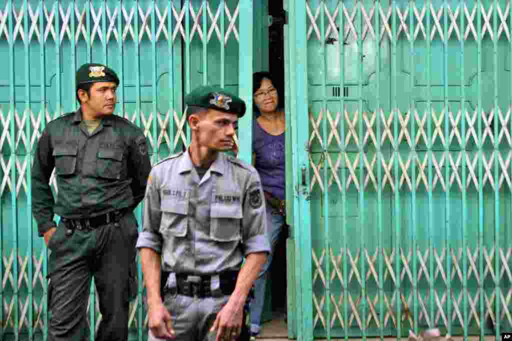 Petugas polisi Syariah berjaga-jaga di luar sebuah restoran yang buka hanya untuk non-Muslim. Polisi berjaga-jaga untuk menghalangi Muslim masuk ke restoran tersebut di hari ketiga Ramadan di Banda Aceh, propinsi Aceh, Indonesia, 1 Juli 2014.