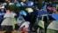 FILE - Migrants, most of them asylum-seekers sent back to Mexico from the U.S. under the "Remain in Mexico" program, officially named Migrant Protection Protocols (MPP), occupy a makeshift encampment in Matamoros, Tamaulipas, Mexico, Oct. 28, 2019.