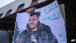 Protesters place a photo of Moroccan rapper Gnawi outside a court where he is on trial on charges of insulting the police, in Sale, Morocco, Nov. 25, 2019.