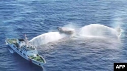 Kapal Garda Pantai China (kiri dan kanan) mengerahkan meriam air ke kapal sipil sewaan militer Filipina Unaizah 4 Mei (tengah) di dekat Second Thomas Shoal di Laut China Selatan yang disengketakan. (Foto: via AFP)