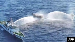 (FILE) Chinese Coast Guard ships deploy water cannons at the Philippine military-chartered civilian boat in the South China Sea.
