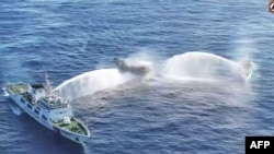 In this frame grab from aerial video footage taken on March 5, 2024, and released by the Philippine coast guard, Chinese coast guard ships deploy water cannons at a Philippine military-chartered civilian boat during its its supply mission in the South China Sea. 