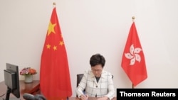 Handout picture of Hong Kong Chief Executive Carrie Lam signing the promulgation of the National Security Law, July 1, 2020.