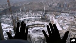 Seorang jemaah haji berdoa dari sebuah hotel yang menghadap ke Ka'bah, di kota suci Mekkah, Arab Saudi, Rabu, 4 Maret 2020. (AP/Amr Nabil)