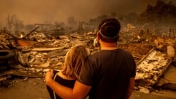 Megan Mantia, kiri, dan pacarnya Thomas, mengunjungi puing-puing rumah Mantia yang musnah dilalap oleh kebakaran hutan di Altadena, California, 8 Januari 2025.